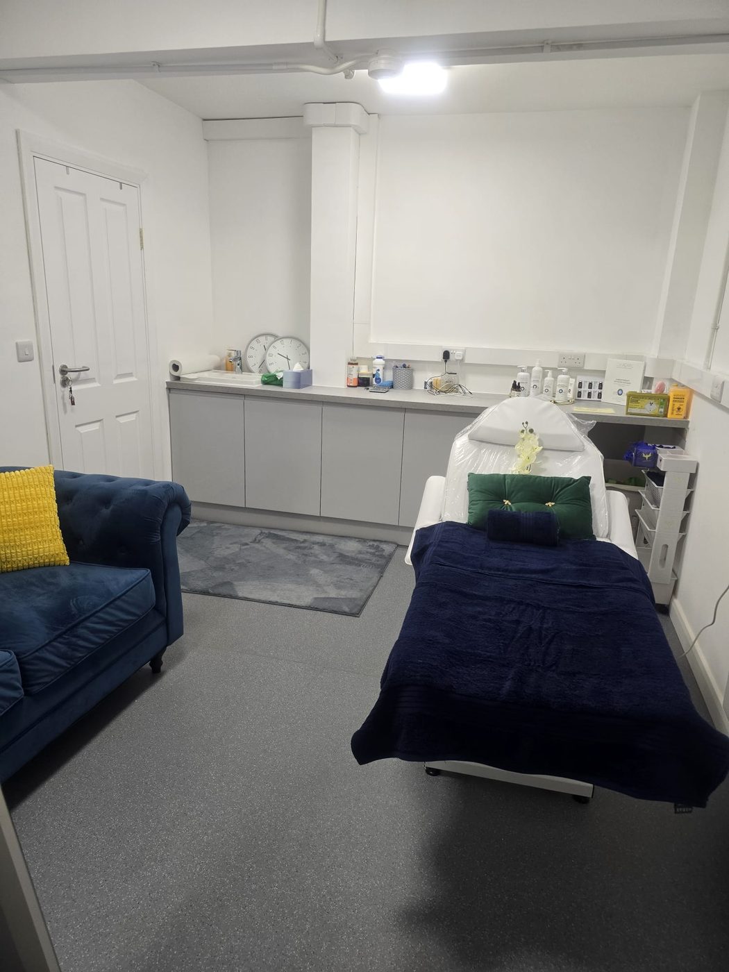 A Laser & Beauty World treatment room with a prepared bed and seating